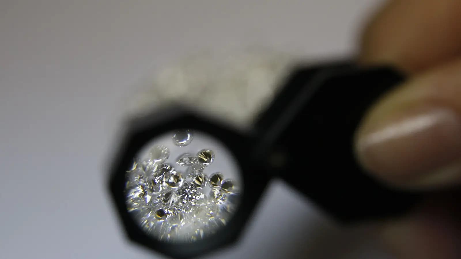 Jeweller's loupe held over a pile of small loose diamonds