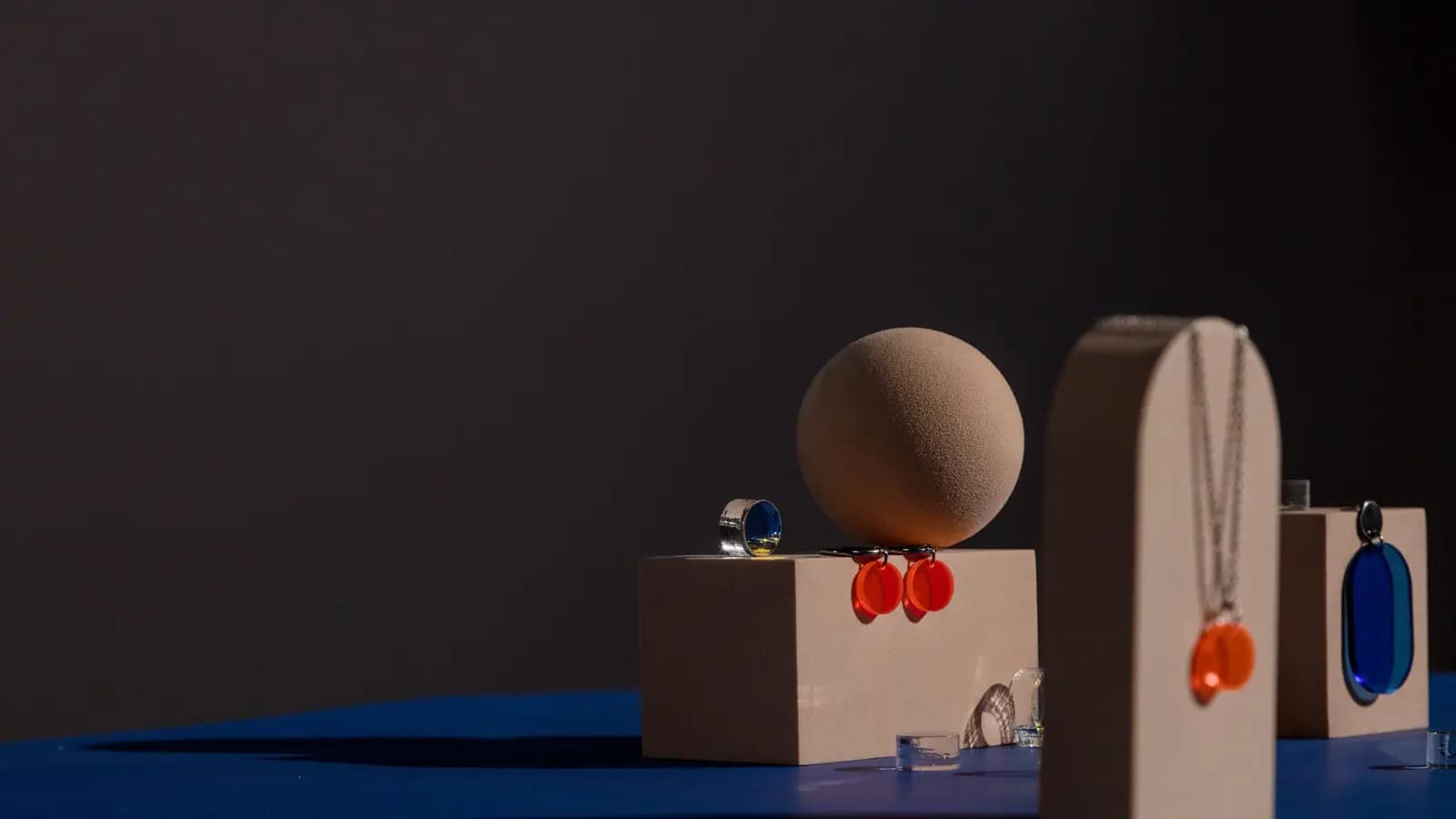 Earrings, a ring and pendants styled on props for a product photo shoot